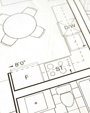 Close-up view of an architectural floor plan on paper showcasing detailed room layouts and measurements.
