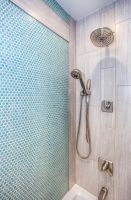 Elegant shower design featuring blue mosaic tiles and stainless steel fixtures.